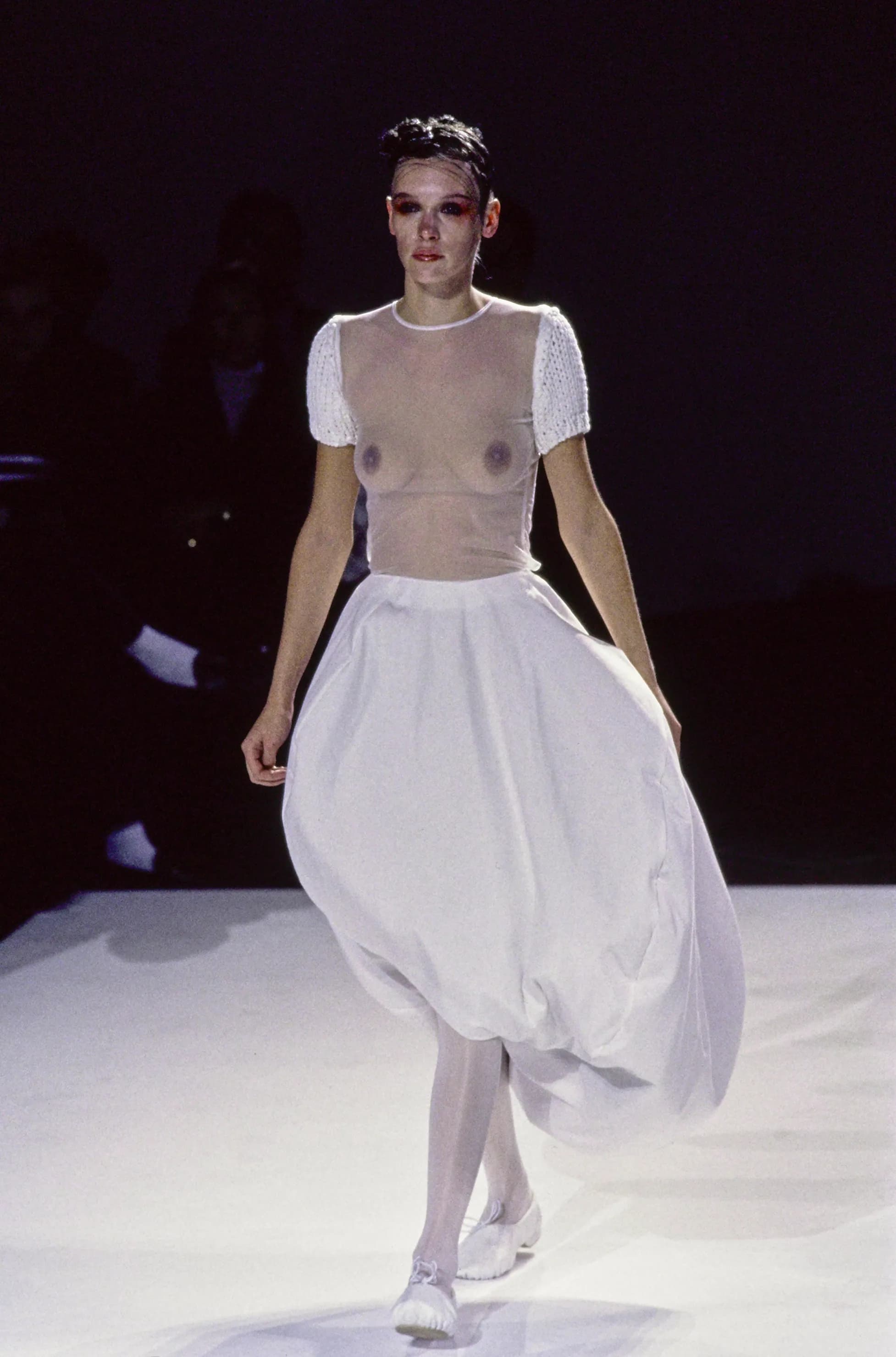 A look from Comme des Garcons spring/summer 1997: stretch gingham carrying down-filled pads at the shoulder, spine or hip, displacing the silhouette into a shape that belongs to no anatomy.