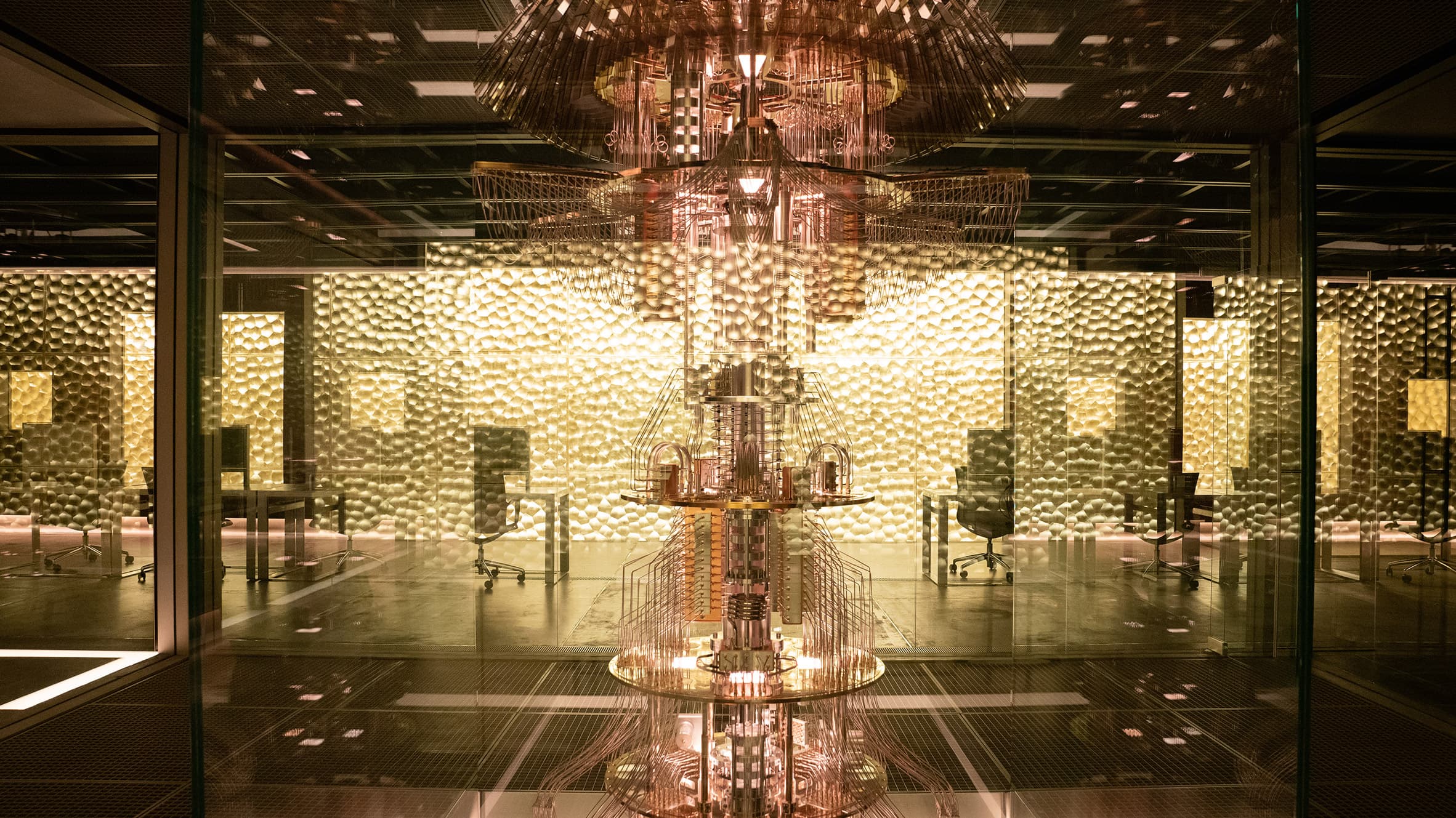 The Devs building interior: a gold-clad cube suspended in a dark vacuum chamber, reached by a walkway over a void.